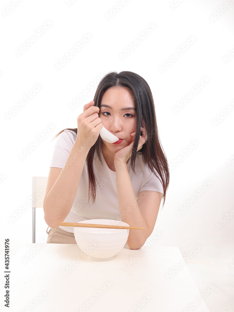 Beautiful young south east Asian woman holding chinese empty chopstick soup spoon bowl utensil pretend acting posing see eat taste feed offer satisfaction yummy white background happy Beautiful young south east Asian woman holding chinese empty chopstick soup spoon bowl utensil pretend acting posing see eat taste feed offer satisfaction yummy white background happy