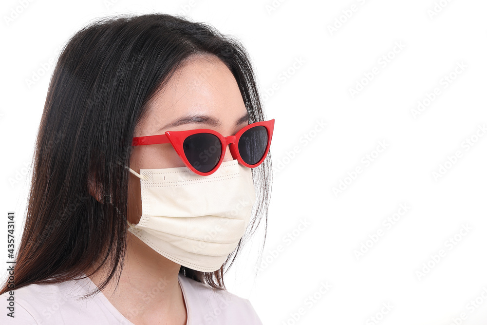 Beautiful young south east Asian woman wearing red frame dark sunglass three ply anti virus surgical face mask pose fashion style white background Beautiful young south east Asian woman wearing red frame dark sunglass three ply anti virus surgical face mask pose fashion style white background
