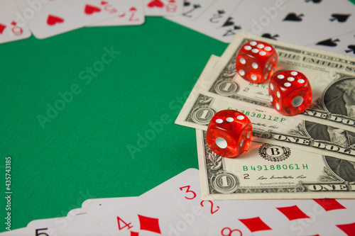 Classic playing cards, red dices and dollars on green background. Gambling and casino concept.