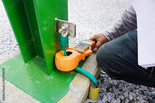 Earth resistance clamp meter during recheck electrical high voltage ground copper bar on steel structure. photo