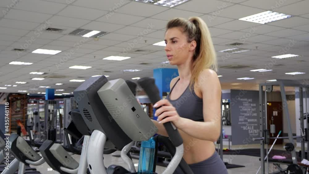 Young woman working out on orbi track at gym exercising Young woman working out on orbi track at gym exercising