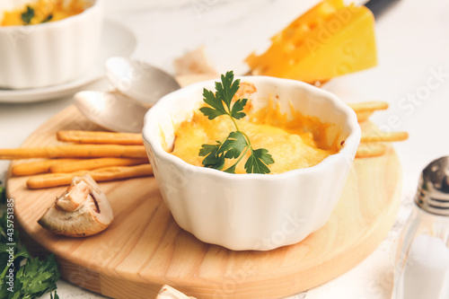Ramekin with tasty julienne and ingredients on light background