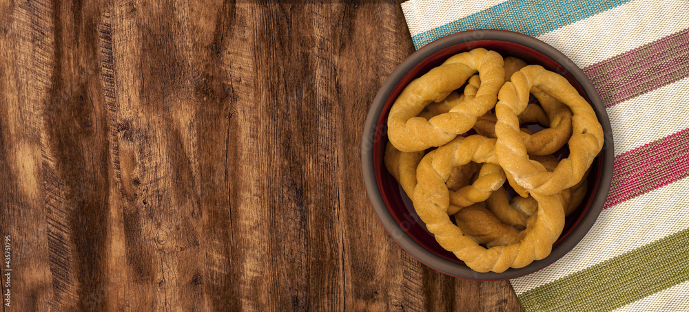 Pieces of traditional Latin American pastry called ROSQUITAS DE SAL or ROSCAS made with wheat flour. Top view of Neapolitan cookies called TARALLI. Stale salt bagels. Wood table. Ecuador Pieces of traditional Latin American pastry called ROSQUITAS DE SAL or ROSCAS made with wheat flour. Top view of Neapolitan cookies called TARALLI. Stale salt bagels. Wood table. Ecuador