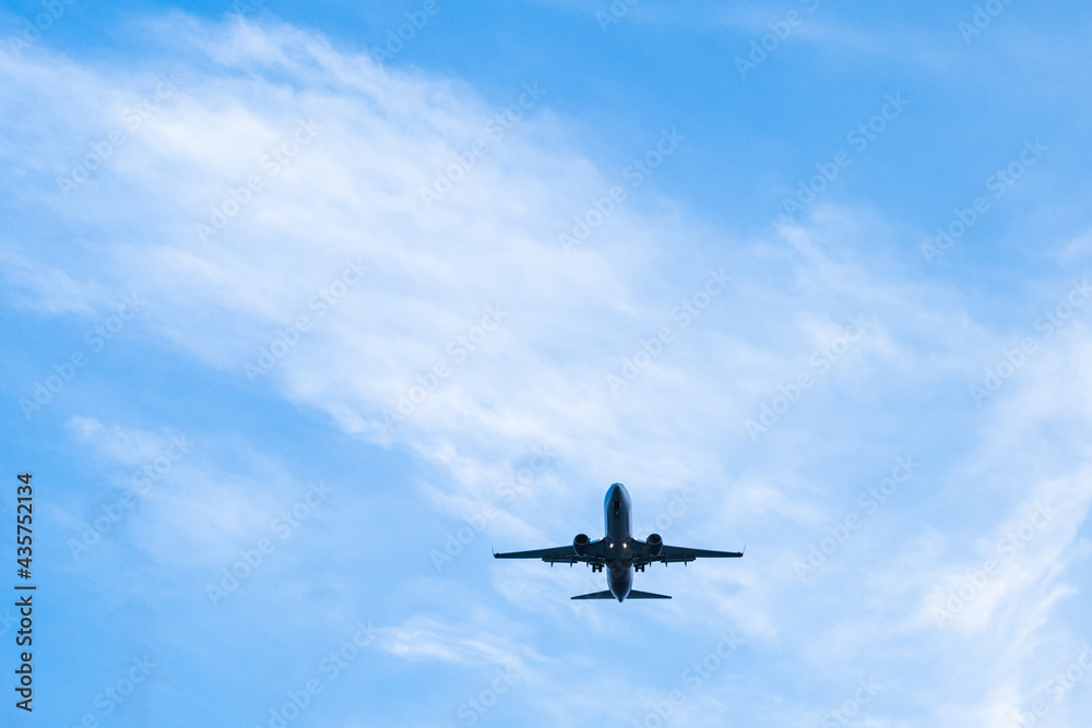 A passenger plane lands on a blue sky background on a warm summer day A passenger plane lands on a blue sky background on a warm summer day