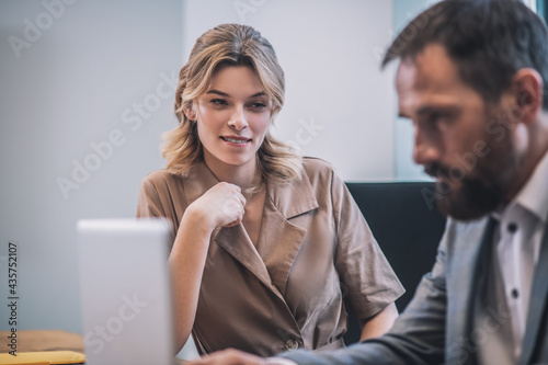 Woman assistant drawing attention of busy boss