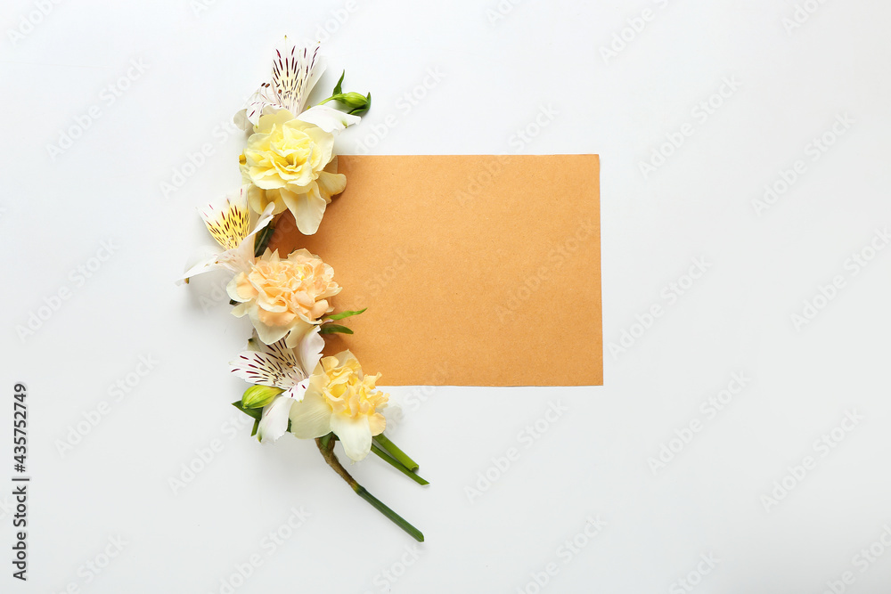 Beautiful flowers and blank card on light background