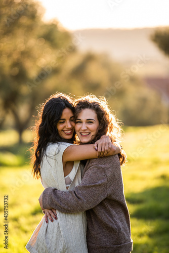 two lesbian girls hugging at sunset in the field. lesbian concept. gay