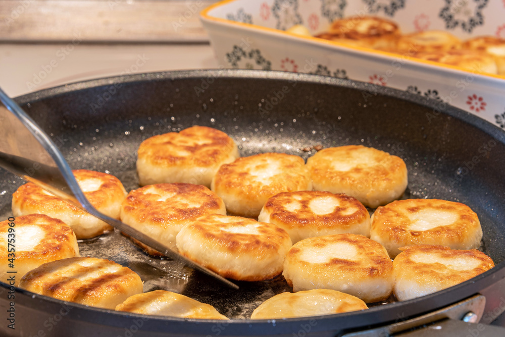Cheesecakes or Syrniki on a pan. Russian and Ukrainian Cuisine Cheesecakes or Syrniki on a pan. Russian and Ukrainian Cuisine