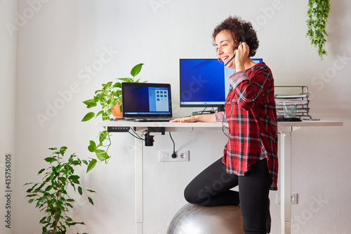 Woman telecommuting at an adjustable standing desk