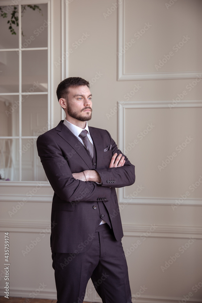 beautiful young man with a beard brunette model. guy in a classic suit in a light stylish interior. beautiful young man with a beard brunette model. guy in a classic suit in a light stylish interior.
