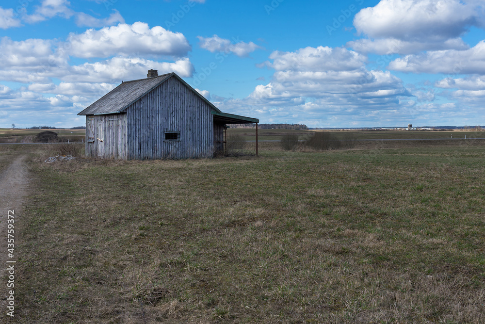 An old abandoned small wooden house in the fields sky clouds, barn or scary concept. An old abandoned small wooden house in the fields sky clouds, barn or scary concept.