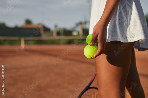 Crop woman in tennis skirt on court