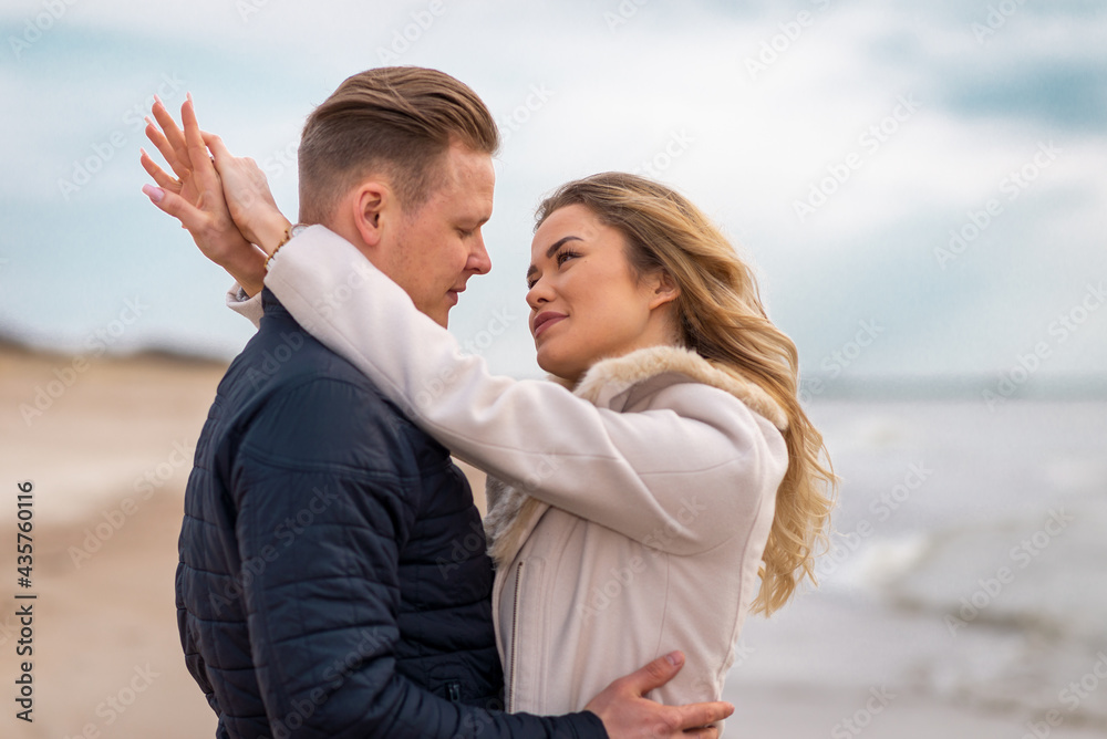 Two Young couple standing enjoying on a sand and enjoying each other.Summer,spring,autumn vacation.