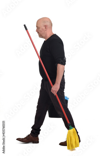 side view of a portrait of man with a mop and bucket looking at camera walking on white background