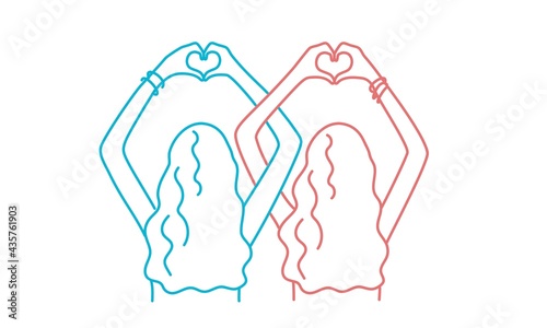 Two girls make a heart shape with their hands. photo