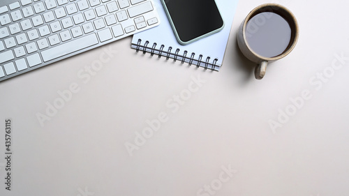 White office desk with mobile phone, notebook and coffee cup.