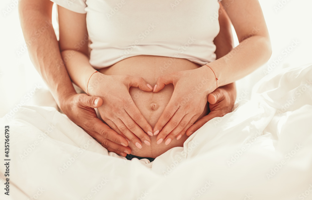 Anonymous couple expecting baby touching belly Anonymous couple expecting baby touching belly