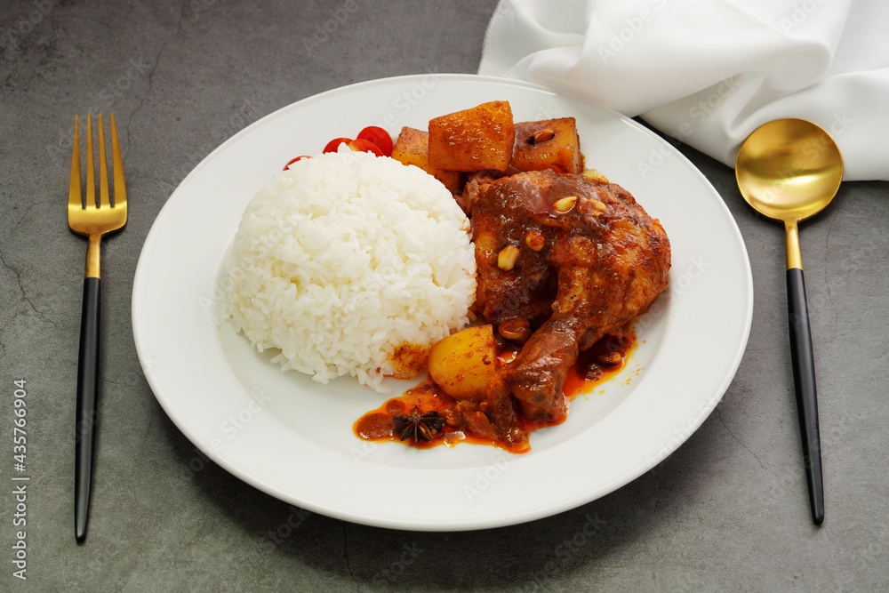 Homemade Massaman Chicken with Chili Paste, Coconut Milk , Steamed Rice on a White Plate Homemade Massaman Chicken with Chili Paste, Coconut Milk , Steamed Rice on a White Plate