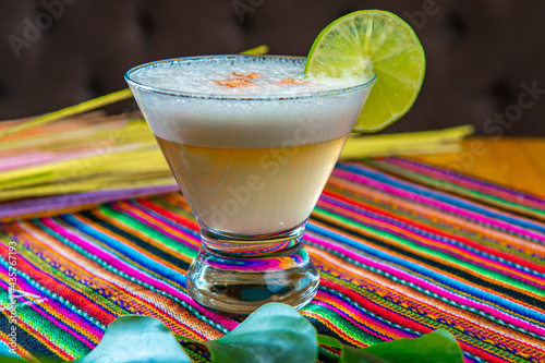Traditional Peruvian pisco sour cocktail with a slice of lime photo