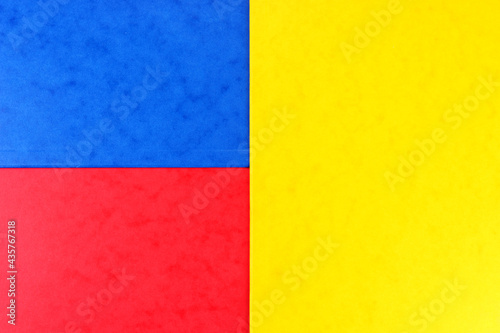 Blue, red and yellow color geometric paper composition background, top view