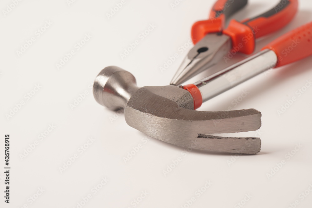Hammer and Pliers on white background. Close up image of standard claw hammer and Needle Nose Pliers Hammer and Pliers on white background. Close up image of standard claw hammer and Needle Nose Pliers