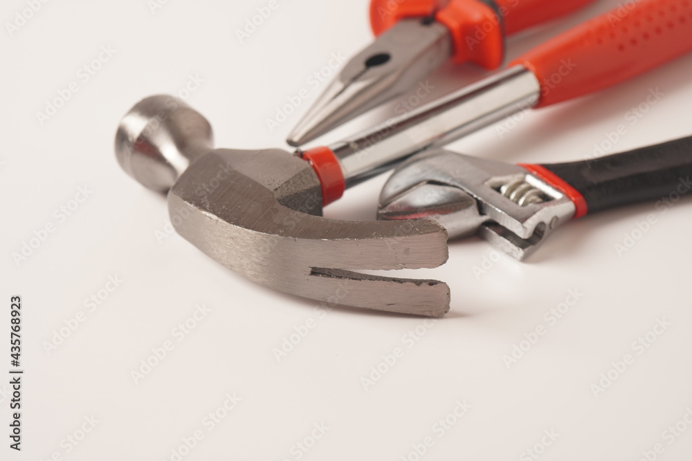 Hammer and Pliers and Adjustable wrench on white background. Close up image of standard claw hammer and Needle Nose Pliers and Adjustable spanner Hammer and Pliers and Adjustable wrench on white background. Close up image of standard claw hammer and Needle Nose Pliers and Adjustable spanner