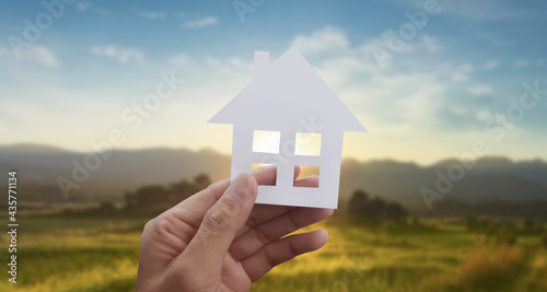 Hands holding paper house, family home protecting insurance concept