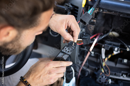 Man working on electronics inside a car © photoschmidt