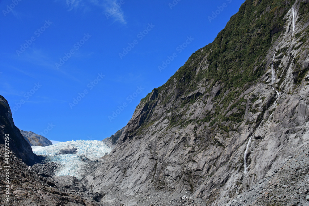 spectacular waterfalls and the terminus of the  franz joseph glacier as seen from the franz joseph glacier walk  overlook on the west coast of the south island of new zealand 