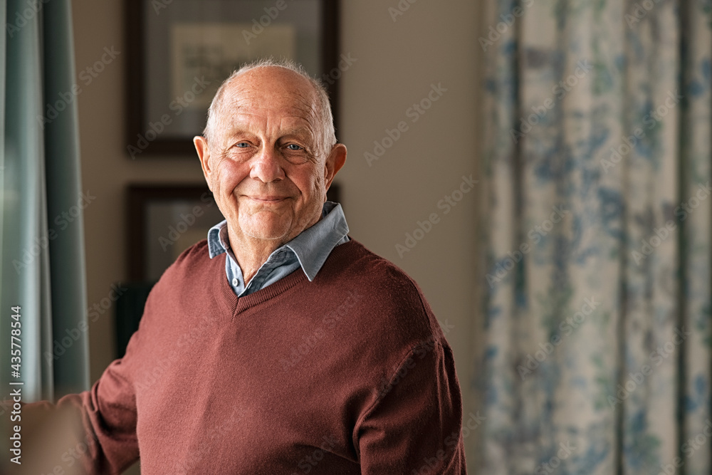 Happy senior man looking at camera at home - obrazy, fototapety, plakaty 