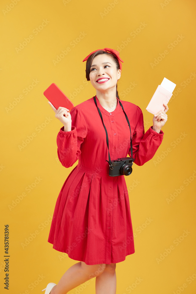 Image of excited young pretty woman tourist posing isolated over yellow wall background holding passport with tickets Image of excited young pretty woman tourist posing isolated over yellow wall background holding passport with tickets