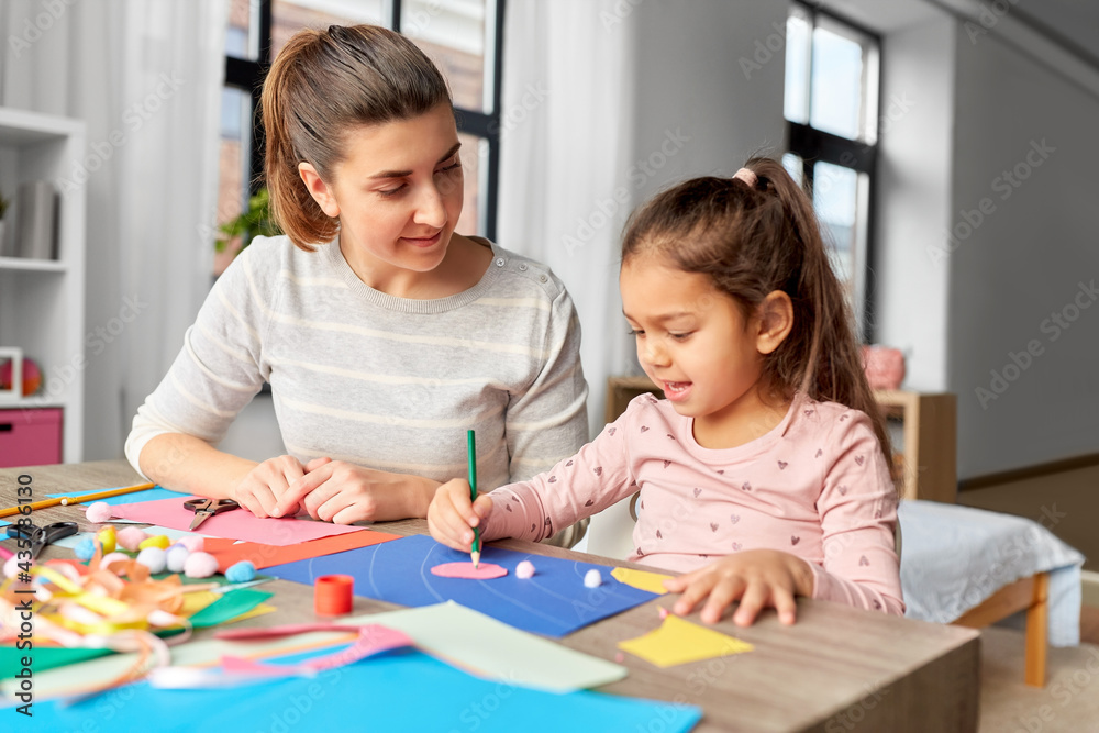 family, art and craft concept - mother spending time with her little daughter making applique of color paper at home family, art and craft concept - mother spending time with her little daughter making applique of color paper at home