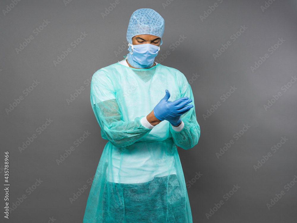 young male doctor putting a blue latex gloves black background young male doctor putting a blue latex gloves black background