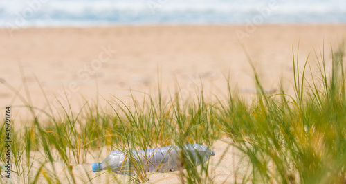 plastic bottle polluting the beach close up