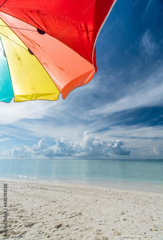 Colorful umbrella on paradise white sand beach and blue sky in sandbank island, Maldives.