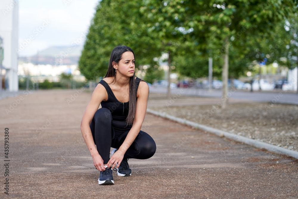 Female model in tying shoelaces before starting exercise Female model in tying shoelaces before starting exercise