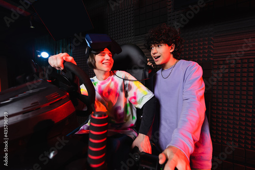 excited boy talking to friend in car racing simulator © LIGHTFIELD STUDIOS