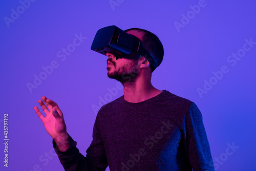 young man working with vr headset device, moving virtual object with his hands. using new technology at work