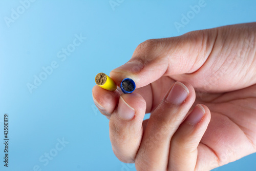 Antibiotic powder in the capsule in hand isolated on a blue background.