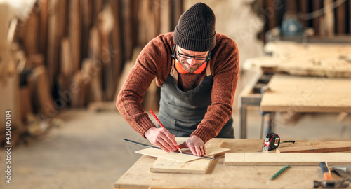 Photos Joiner making marks on wooden detail