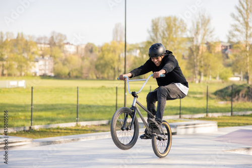 Men mastered riding a low trick bike,bmx, I try to lift the front wheel, he is fascinated, smiles, keeps his feet on the pedals lifting himself up