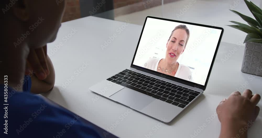 Mid section of african american woman having a video call on laptop with female colleague at office Mid section of african american woman having a video call on laptop with female colleague at office