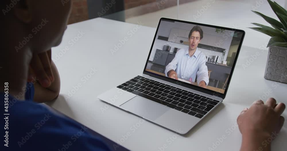 Mid section of african american woman having a video call with male colleague on laptop at office Mid section of african american woman having a video call with male colleague on laptop at office