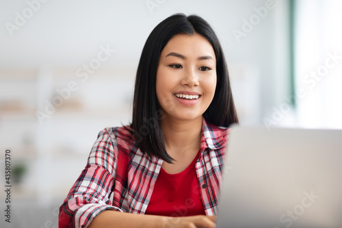 Online Education. Happy young asian woman study with laptop at home