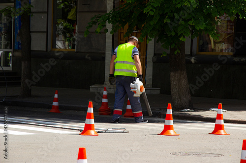 Worker applies road markings, markings for cars