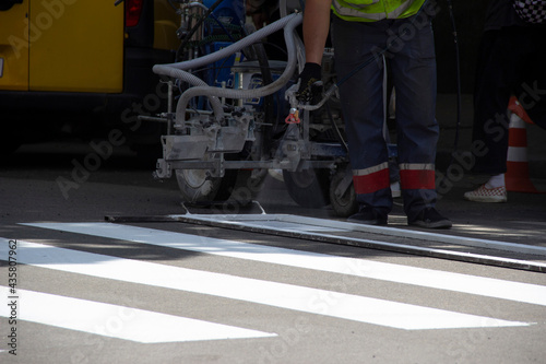 Worker applies road markings, markings for cars