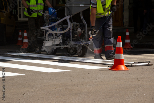 Worker applies road markings, markings for cars