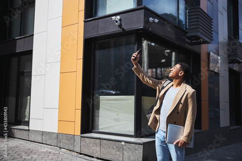 Cheerful freelancer taking selfie photo on telephone