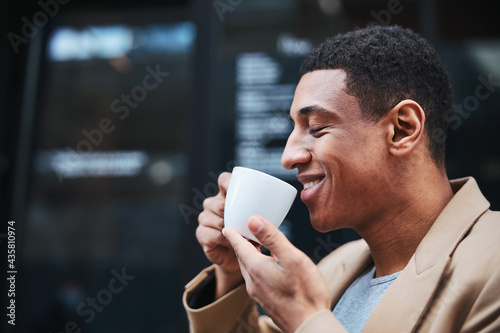 Pleased male person enjoying favorite smell of coffee