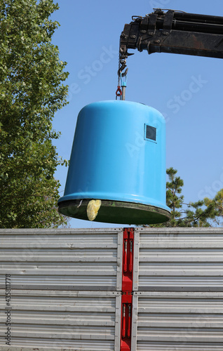 crane and recycling bin and a truck during emptying photo